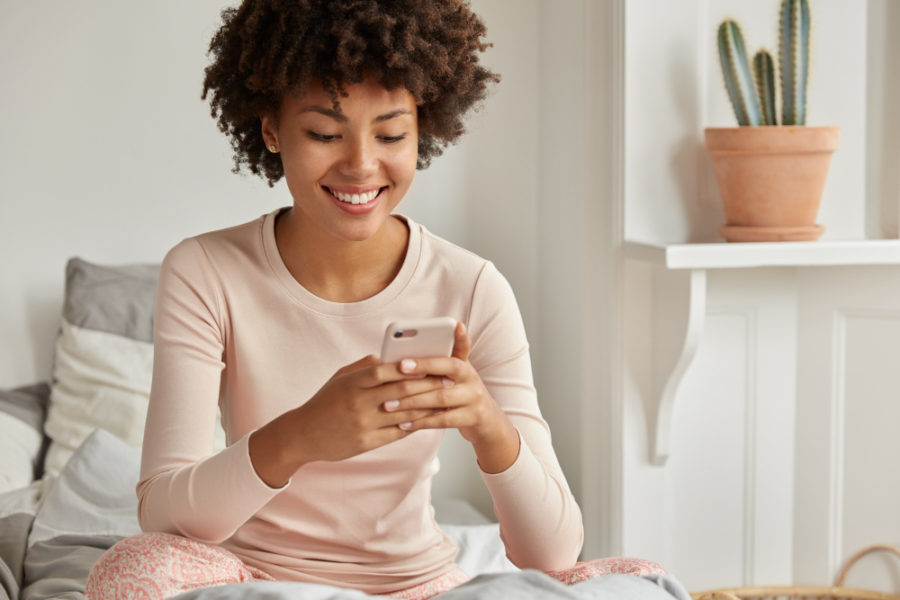 Imagem de uma mulher realizando uma pesquisa de satisfação no celular, imagem relacionada com NPS