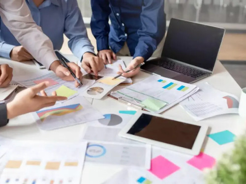 Imagem com pessoas planejamento algo com as mãos em cima de papeis que estão em uma mesa com Data Driven